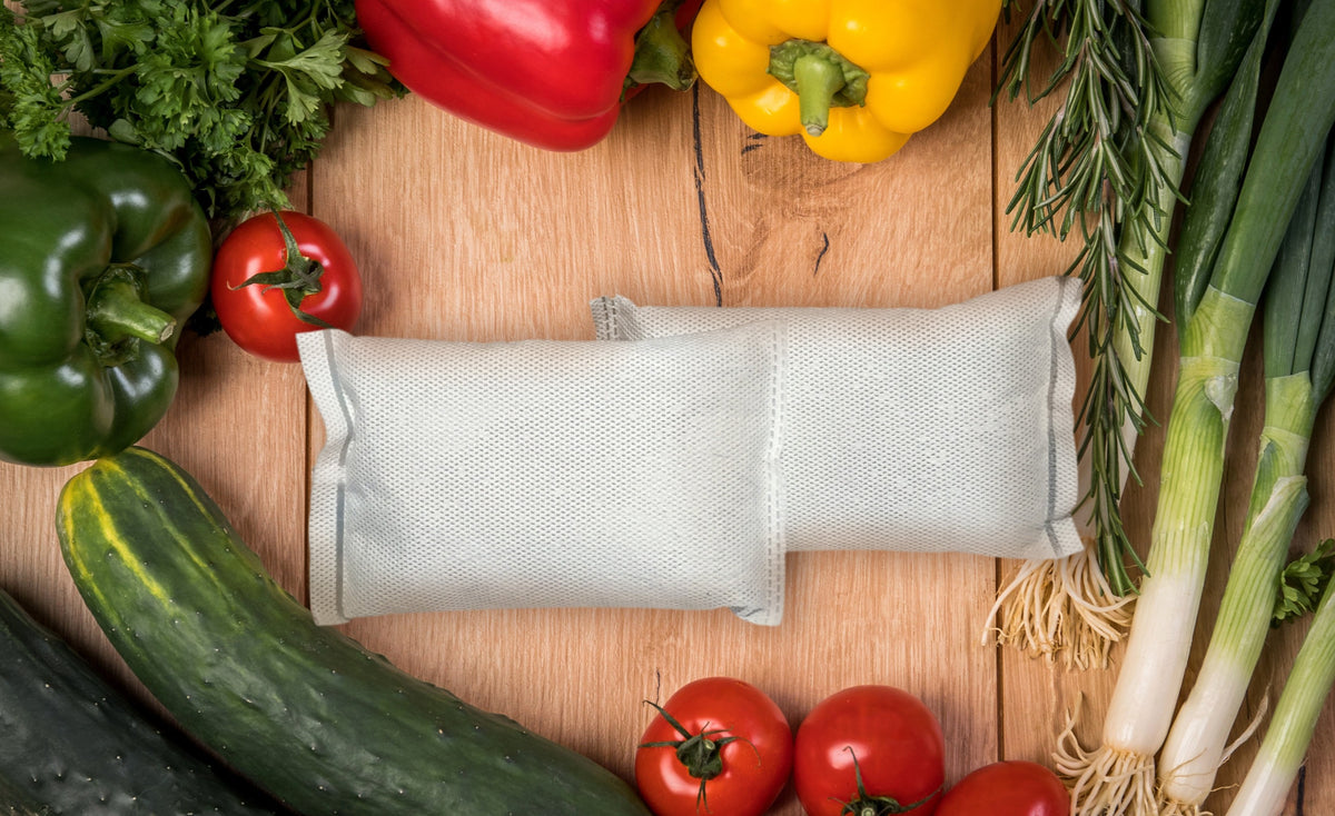 Image of two Freshly Fridge Packs next to various vegetables.